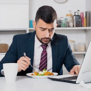 manager qui mange seul, isolé de son équipe. motivation au travail